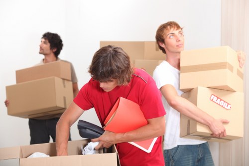 Professional movers carrying furniture from a flat in Kennington